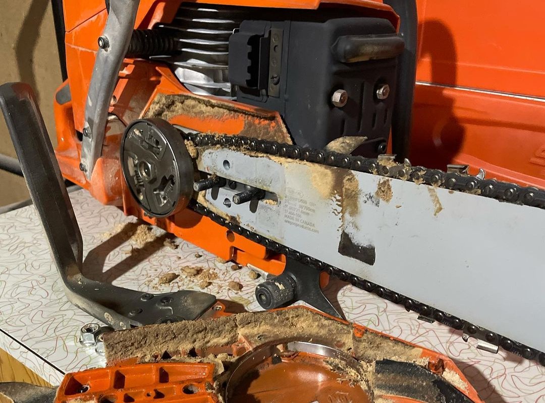 Disassembled chainsaw lying on table